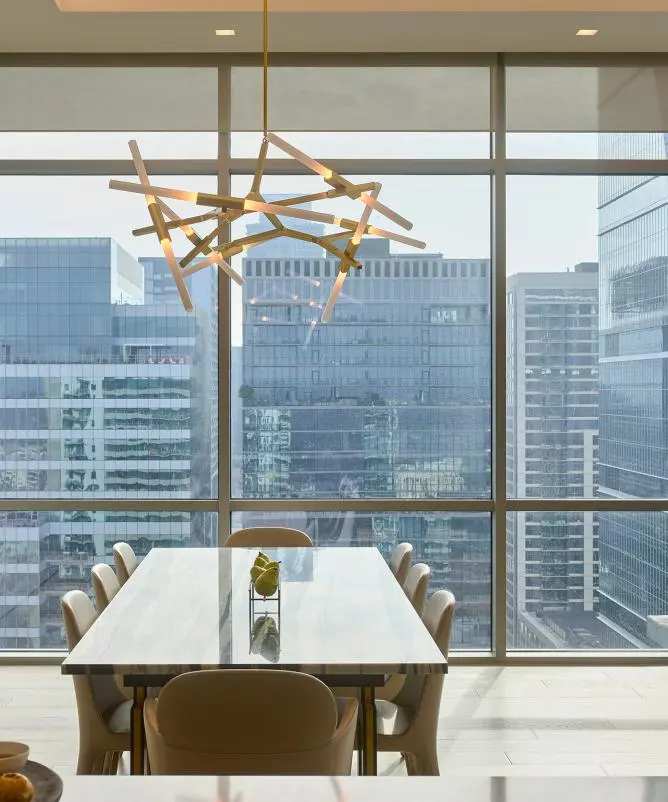 Dining room with roller shades raised to frame a city view