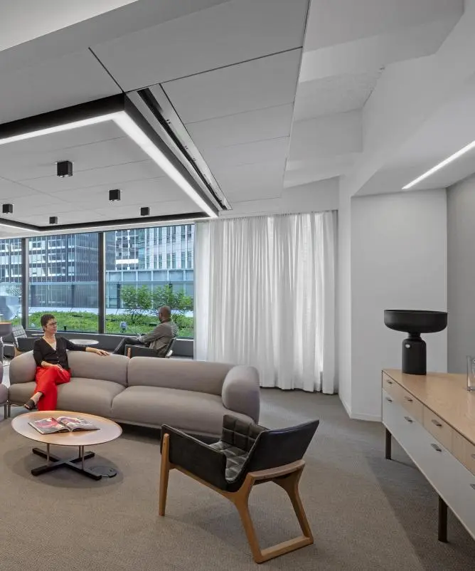 Lounge with motorized sheer white drapery across a window wall